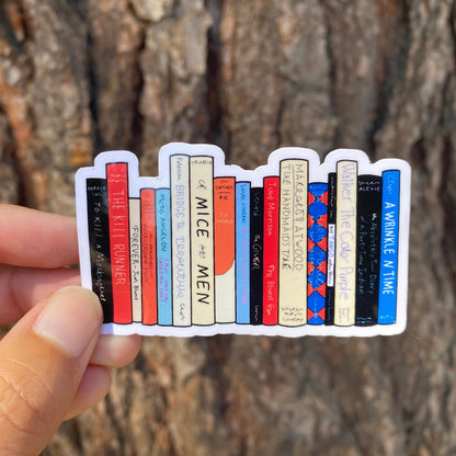Sticker of books held by a hand against a tree bark background