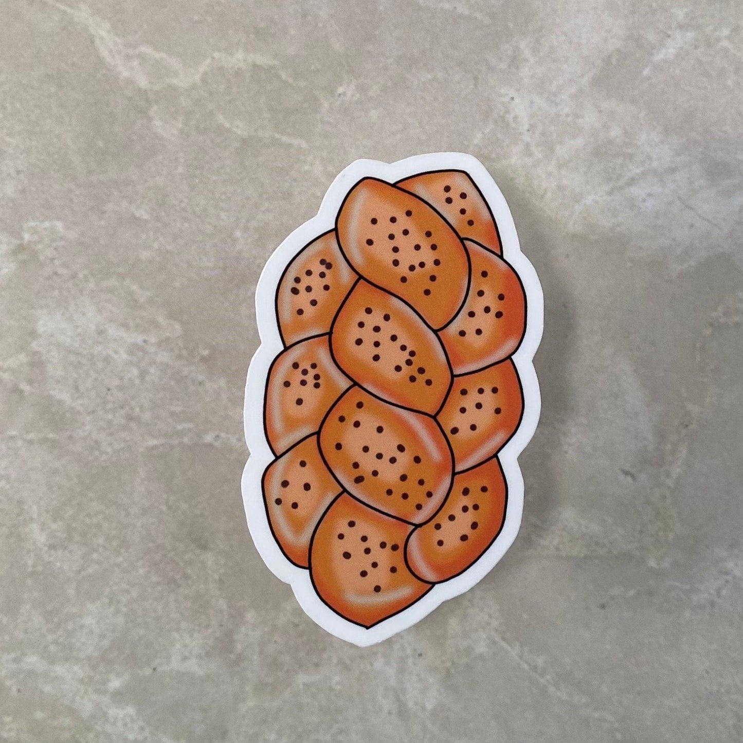 Sticker of a loaf of bread with sesame seeds on a gray surface