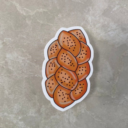 Sticker of a loaf of bread with sesame seeds on a gray surface