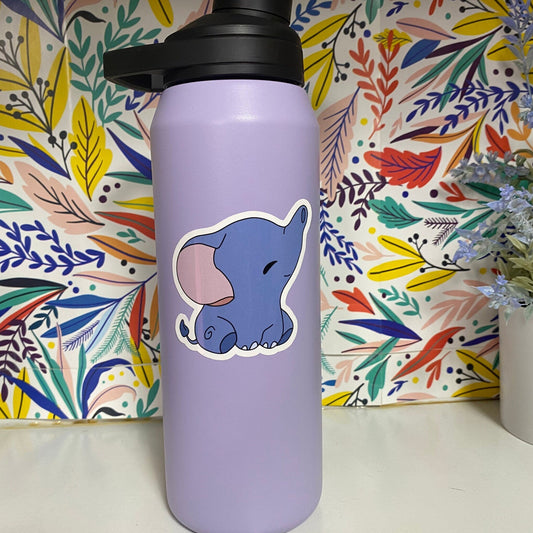 Purple water bottle with a cartoon elephant sticker against a colorful floral background