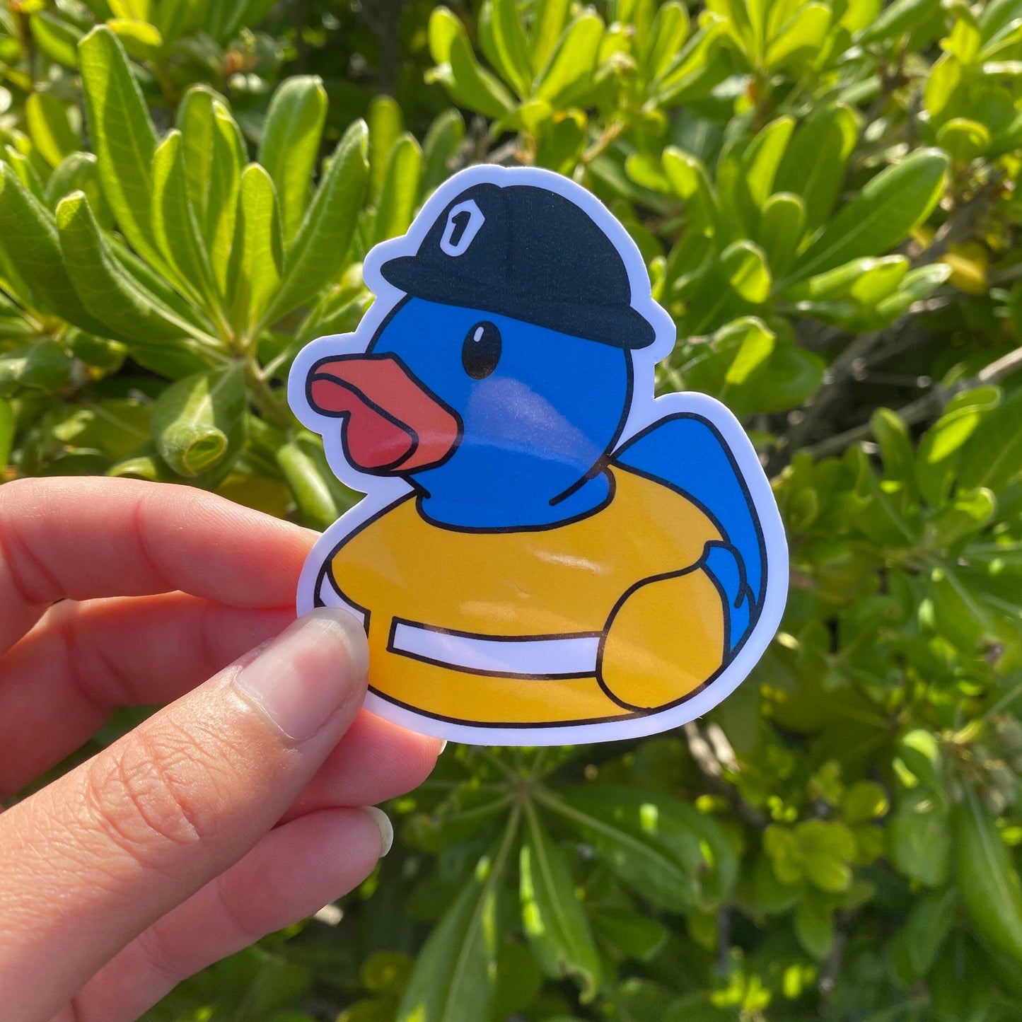 Sticker of a blue duck wearing a firefighter outfit