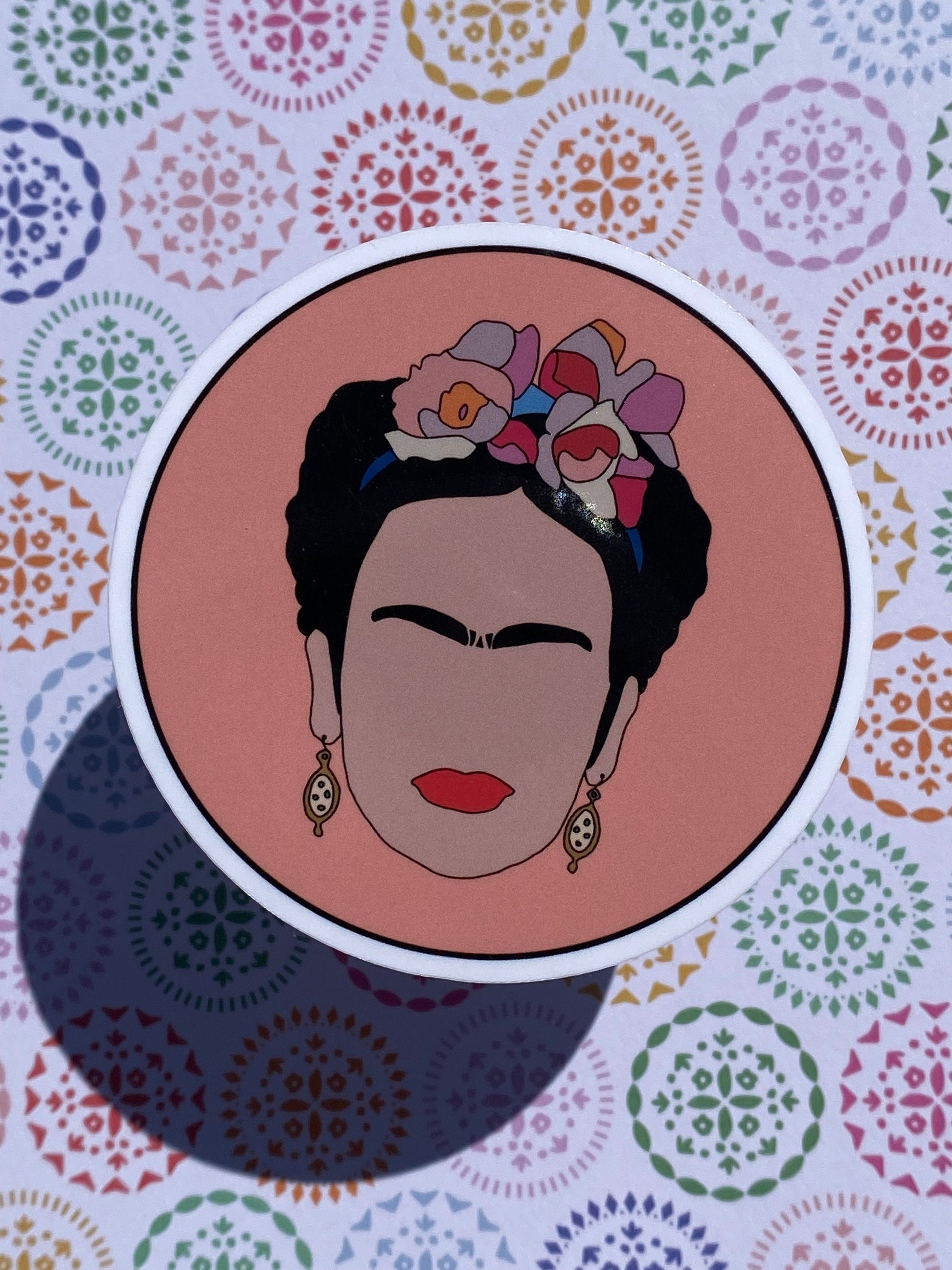 Illustration of Frida Kahlo with floral headpiece on a colorful patterned background