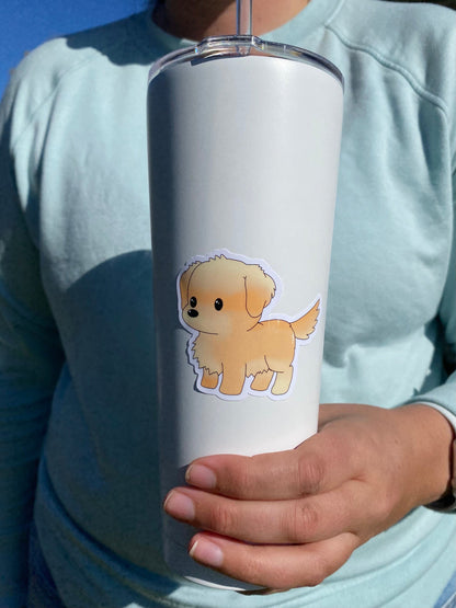 Person holding a white tumbler with a dog sticker against a blue background