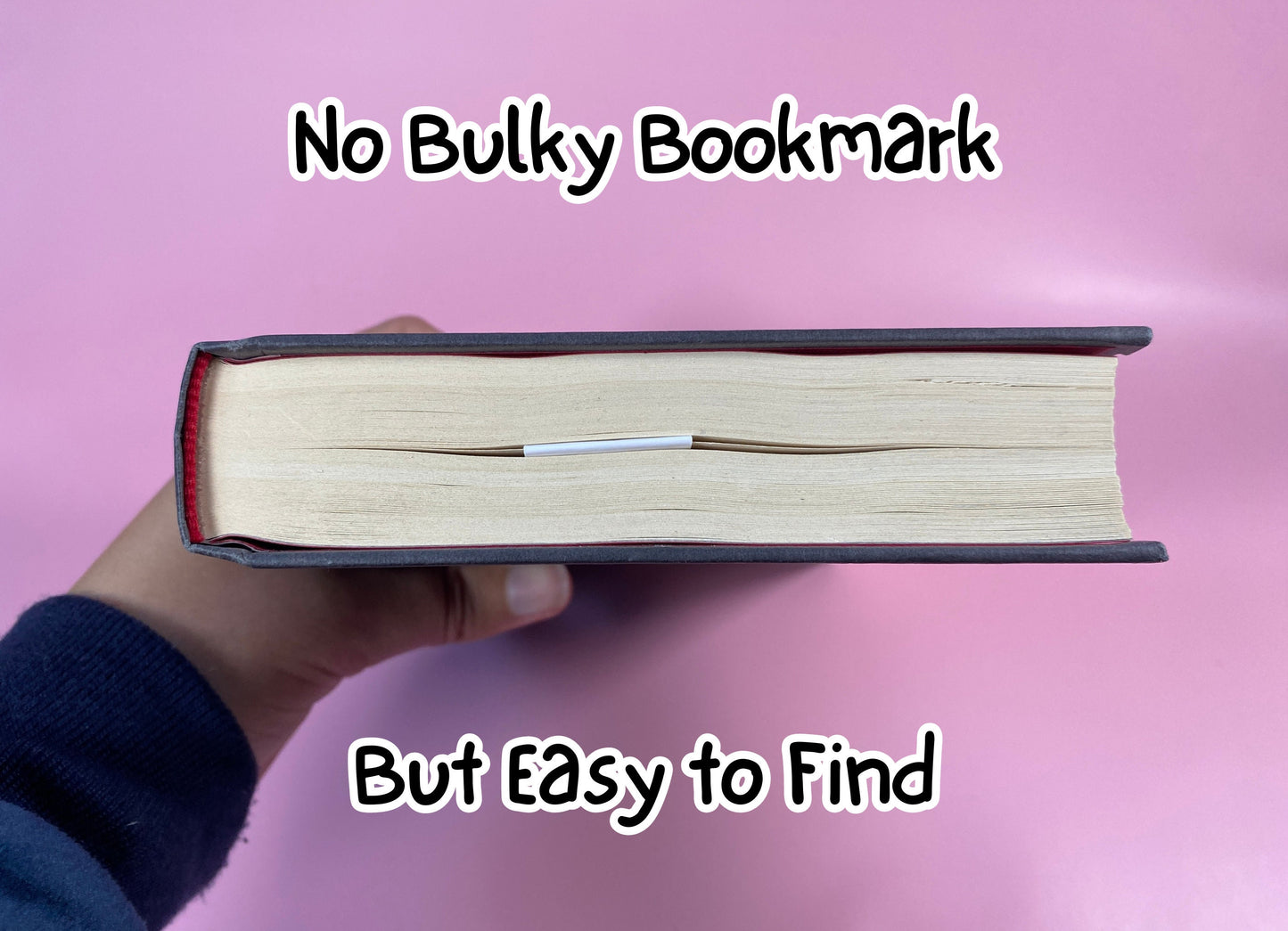 Hand holding a book with a magnetic bookmark saving a page on a pink background, text 'No Bulky Bookmark But Easy to Find' above.