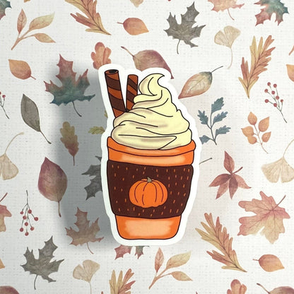 Sticker of a pumpkin spice latte with whipped cream on a leaf patterned background