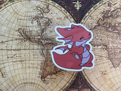 Sticker of a red dragon on an old world map